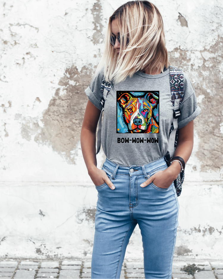 A person wearing a gray t-shirt with a colorful dog graphic and the text &