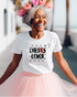 A person wearing a pink tutu and a white t-shirt with the text &