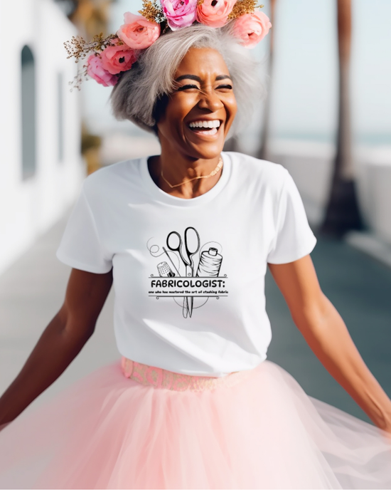 Woman wearing a white t-shirt with a graphic design and text, smiling outdoors.