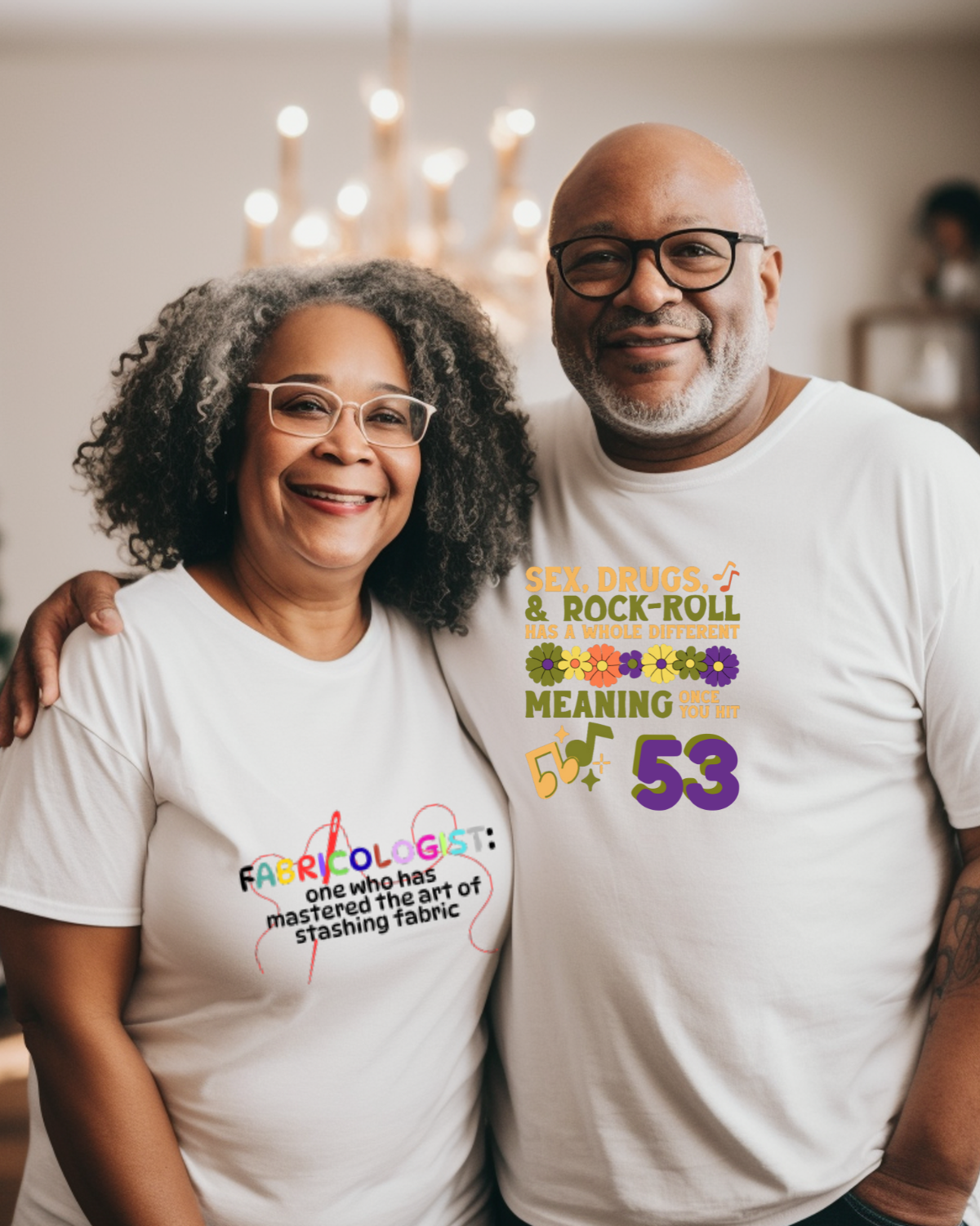 Two people wearing white t-shirts with colorful text and graphics.Her t-shirt has a colorful Fabricologist graphic and his has a birthday wish "sex, drugs, and rrock-roll have a different meaning at 53"