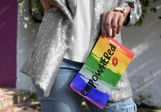 Person holding a rainbow-colored pouch with &