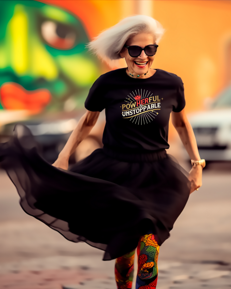 Woman wearing a black t-shirt with motivational text, colorful leggings, and sunglasses, dancing in an urban setting.