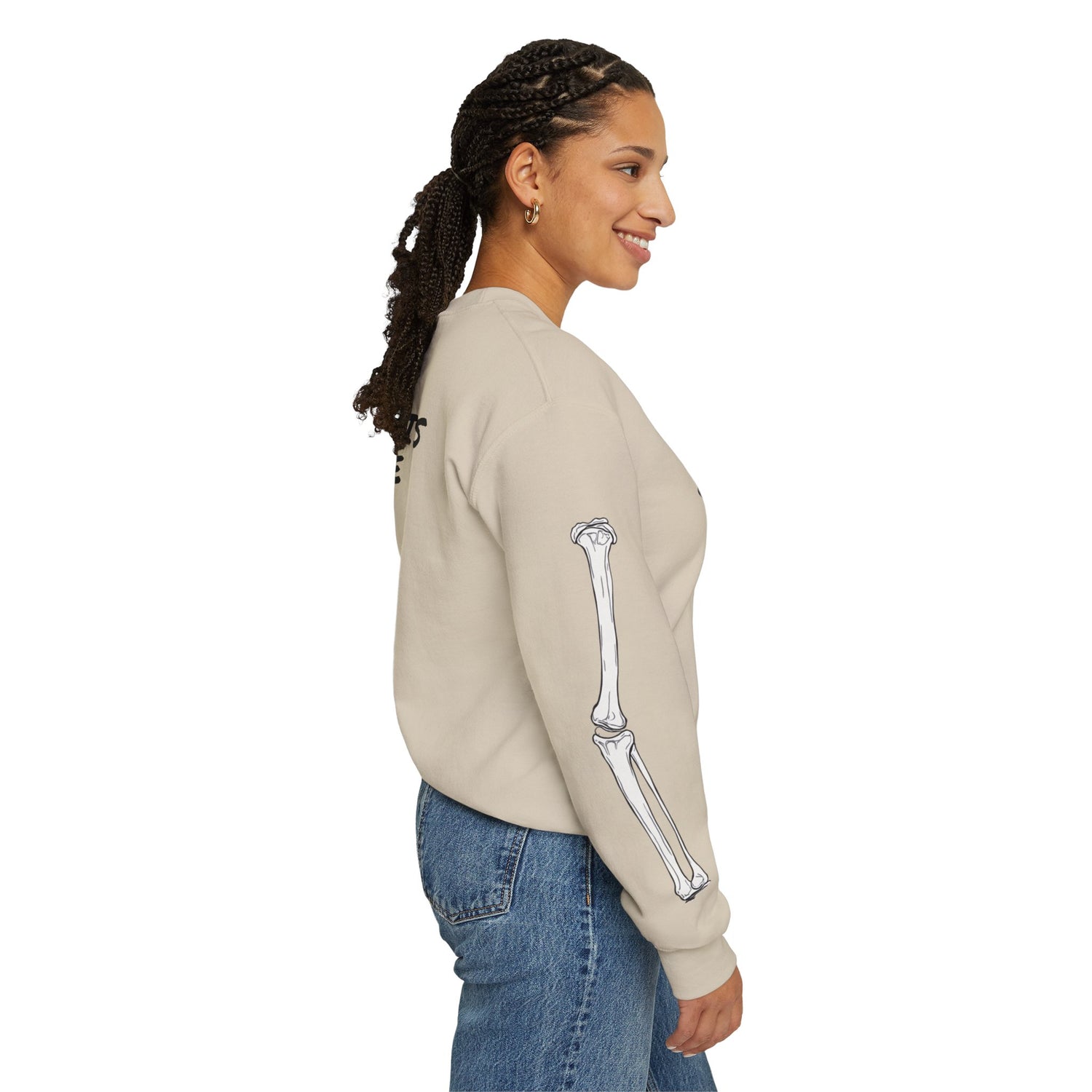 Woman wearing a beige sweatshirt with a skeleton arm design on a white background