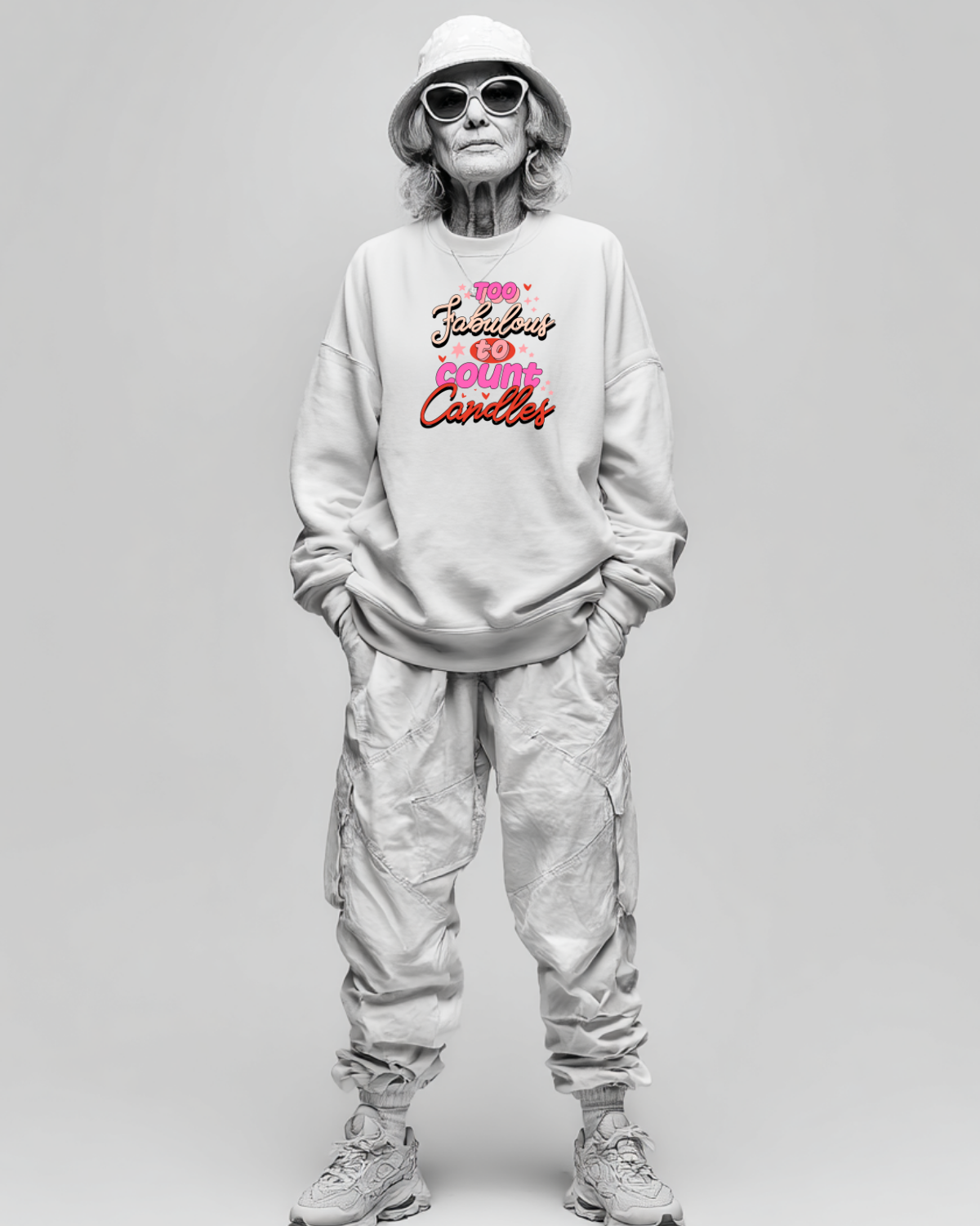 Person wearing a light gray sweatshirt with colorful text birthday graphic and light gray pants on a plain background