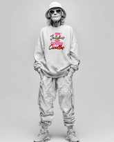 Person wearing a light gray sweatshirt with colorful text birthday graphic and light gray pants on a plain background