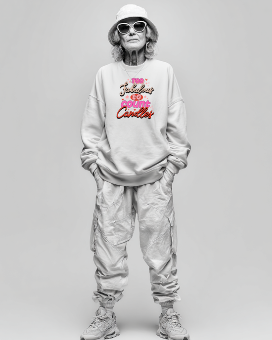 Person wearing a light gray sweatshirt with colorful text birthday graphic and light gray pants on a plain background