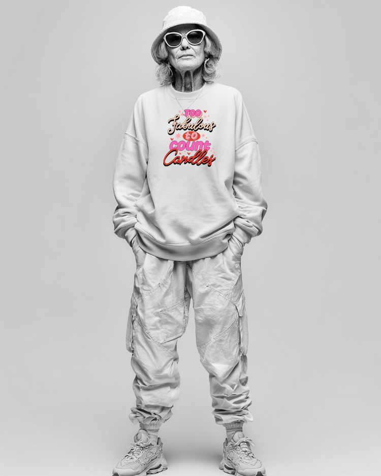 Person wearing a light gray sweatshirt with colorful text birthday graphic and light gray pants on a plain background