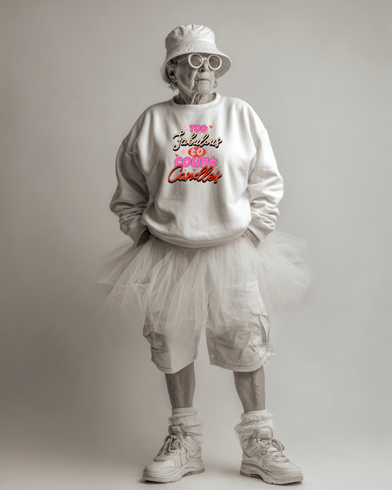 Person wearing a white sweatshirt with colorful text "Too fabulous to county candles", white shorts, and a white bucket hat on a plain background