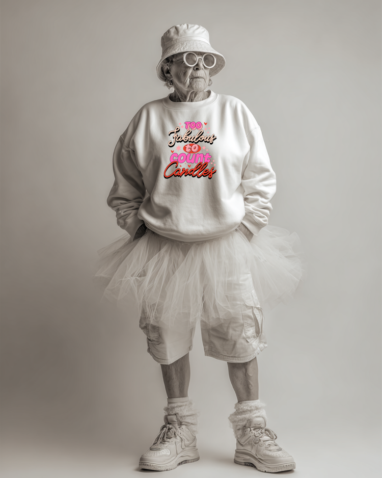 Person wearing a white sweatshirt with colorful text "Too fabulous to county candles", white shorts, and a white bucket hat on a plain background
