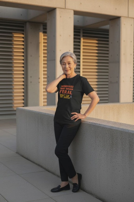 Woman wearing black tshirt with text "Menopause Made Momma Feral"